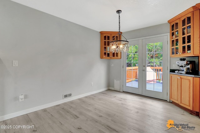 8461 Greenhill Way, Anchorage, AK 99502 - unfurnished dining area with light wood-type flooring, a chandelier, and french doors