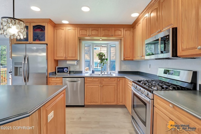 8461 Greenhill Way, Anchorage, AK 99502 - kitchen with stainless steel appliances, dark countertops, light wood finished floors, recessed lighting, and hanging light fixtures