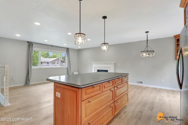 8461 Greenhill Way, Anchorage, AK 99502 - kitchen with dark countertops, a chandelier, light wood-type flooring, a brick fireplace, and recessed lighting