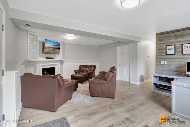 8461 Greenhill Way, Anchorage, AK 99502 - living area with a warm lit fireplace and light wood-type flooring