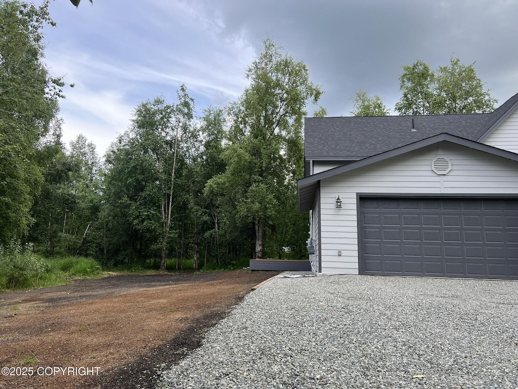 3271 N Bald Eagle Dr, Wasilla, AK 99654 - view of side of property featuring a garage, a shingled roof, and driveway