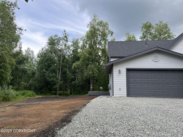 3271 N Bald Eagle Dr, Wasilla, AK 99654 - view of side of property featuring a garage, a shingled roof, and driveway