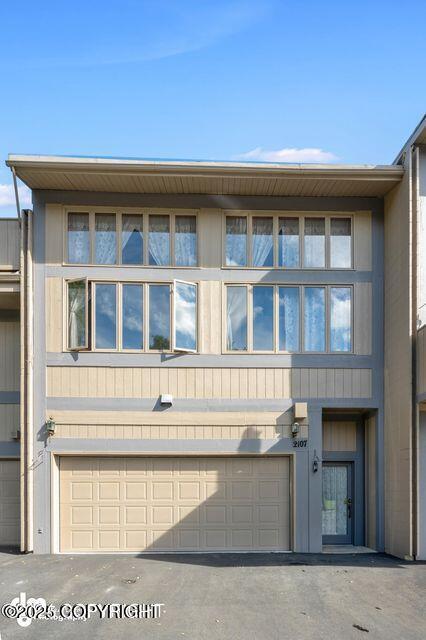 2107 Sorbus Way, Anchorage, AK 99508 - rear view of house with a garage and asphalt driveway