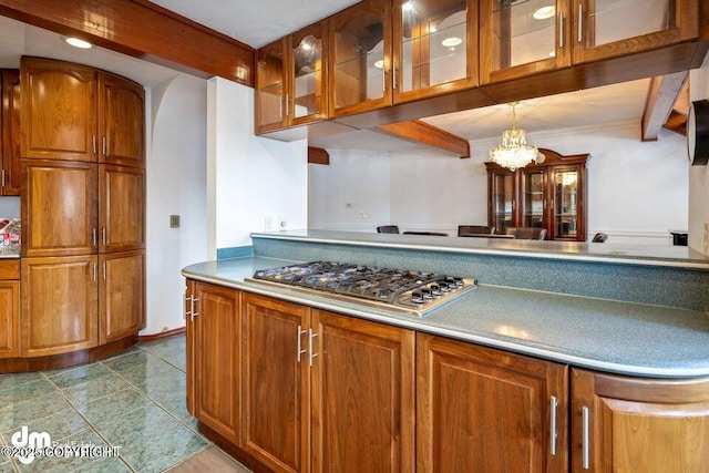 2107 Sorbus Way, Anchorage, AK 99508 - kitchen with stainless steel gas cooktop, brown cabinets, glass insert cabinets, beamed ceiling, and tile patterned flooring