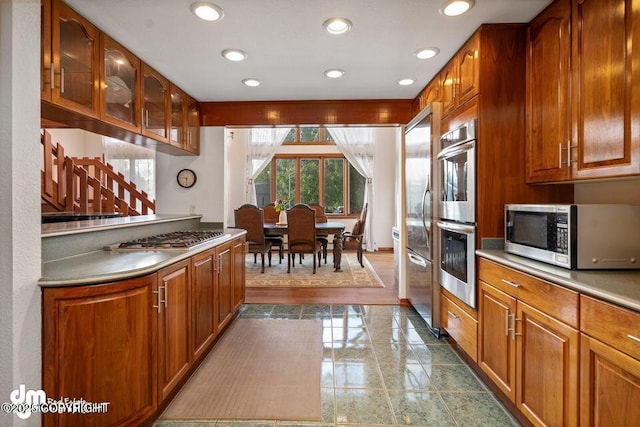 2107 Sorbus Way, Anchorage, AK 99508 - kitchen with appliances with stainless steel finishes, healthy amount of natural light, brown cabinets, glass insert cabinets, and recessed lighting