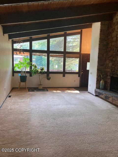 2531 W 79th Ave, Anchorage, AK 99502 - unfurnished room with light colored carpet, a wood ceiling with exposed beams, and a fireplace