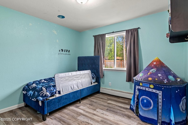 1119 Alder Ave, Kenai, AK 99611 - bedroom featuring a baseboard heating unit and wood finished floors