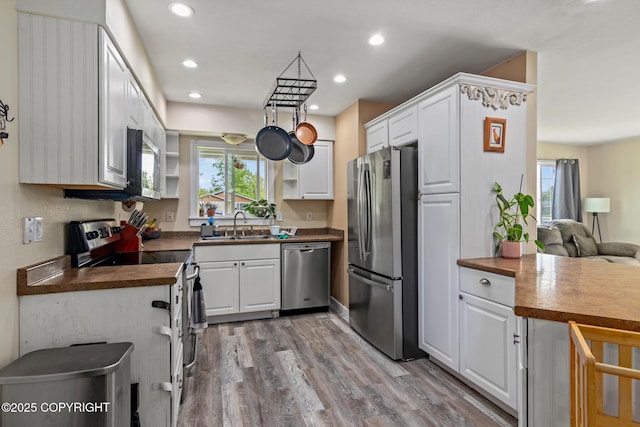 1119 Alder Ave, Kenai, AK 99611 - kitchen featuring appliances with stainless steel finishes, white cabinets, recessed lighting, light wood-style floors, and wood counters
