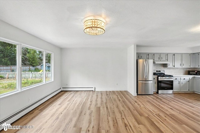 173 W Corral Ave, Soldotna, AK 99669 - kitchen with stainless steel appliances, gray cabinetry, a baseboard radiator, light wood-style flooring, and light countertops