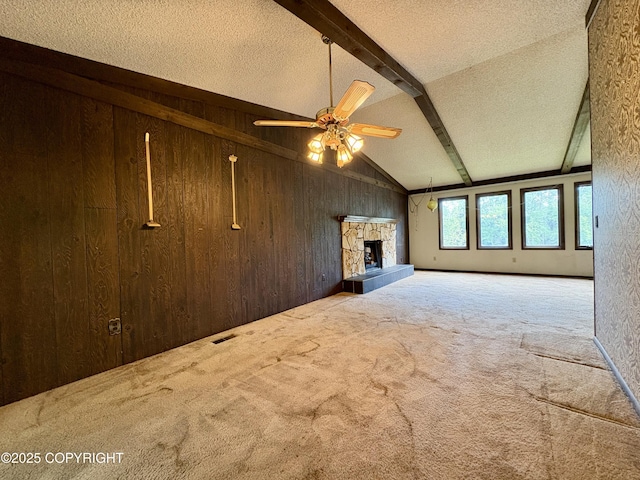 8204 E 17th Ave, Anchorage, AK 99504 - unfurnished living room with wood walls, carpet, a ceiling fan, a fireplace, and a textured ceiling
