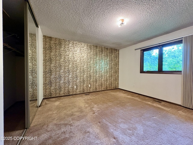 8204 E 17th Ave, Anchorage, AK 99504 - spare room with wallpapered walls, a textured ceiling, and carpet floors