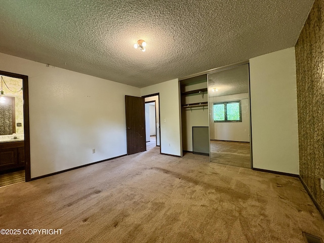 8204 E 17th Ave, Anchorage, AK 99504 - unfurnished bedroom with light carpet, a textured ceiling, a closet, and ensuite bath