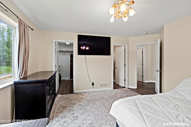 369 Breeze Ct # 13, Anchorage, AK 99515 - bedroom featuring a chandelier, a spacious closet, dark wood-type flooring, and a closet