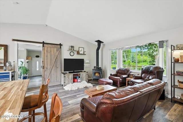 16720 E Maud Rd, Palmer, AK 99645 - living room with vaulted ceiling, wood finished floors, a wood stove, and a barn door