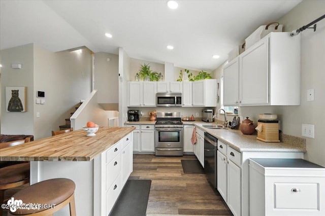 16720 E Maud Rd, Palmer, AK 99645 - kitchen with stainless steel appliances, a kitchen bar, vaulted ceiling, white cabinets, and a center island