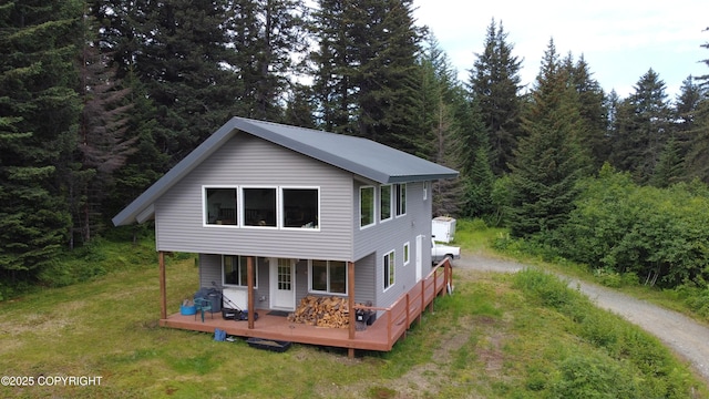 2008 Bickford Cir, Seldovia, AK 99663 - back of property with driveway, a wooded view, and a lawn