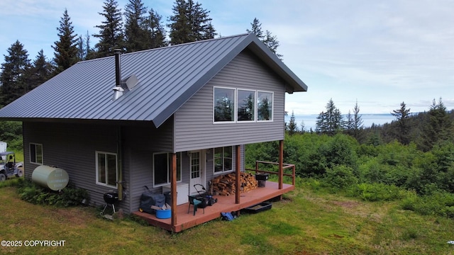 2008 Bickford Cir, Seldovia, AK 99663 - rear view of property with a deck, a standing seam roof, a yard, a metal roof, and a forest view