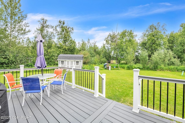 5305 N Caprice Dr, Palmer, AK 99645 - wooden deck with outdoor dining space, a storage shed, a playground, a yard, and view of scattered trees