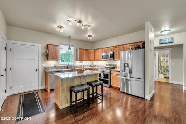 5305 N Caprice Dr, Palmer, AK 99645 - kitchen with stainless steel appliances, a kitchen island, a kitchen breakfast bar, dark wood finished floors, and light stone counters