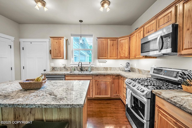 5305 N Caprice Dr, Palmer, AK 99645 - kitchen featuring appliances with stainless steel finishes, dark wood-style flooring, light stone counters, decorative light fixtures, and a kitchen island
