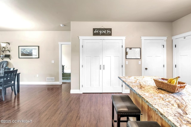 5305 N Caprice Dr, Palmer, AK 99645 - kitchen featuring a breakfast bar, dark wood-style flooring, and light stone counters