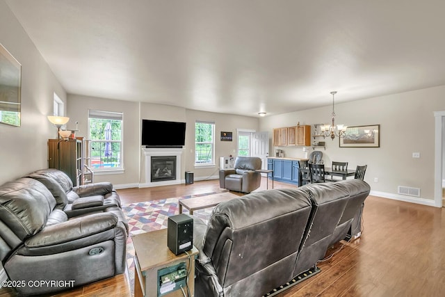 5305 N Caprice Dr, Palmer, AK 99645 - living room featuring wood finished floors, a chandelier, and a glass covered fireplace