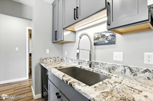 3601 Oregon Dr # 1, Anchorage, AK 99517 - kitchen with wood finished floors, light stone countertops, gray cabinets, and dishwasher