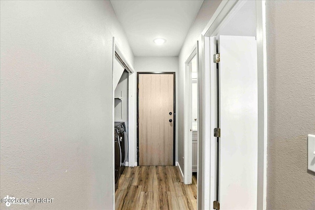 3601 Oregon Dr # 1, Anchorage, AK 99517 - corridor featuring a textured wall, light wood-style flooring, and washer / dryer