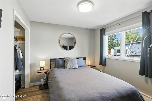 3601 Oregon Dr # 1, Anchorage, AK 99517 - bedroom with wood finished floors, a closet, and a baseboard radiator