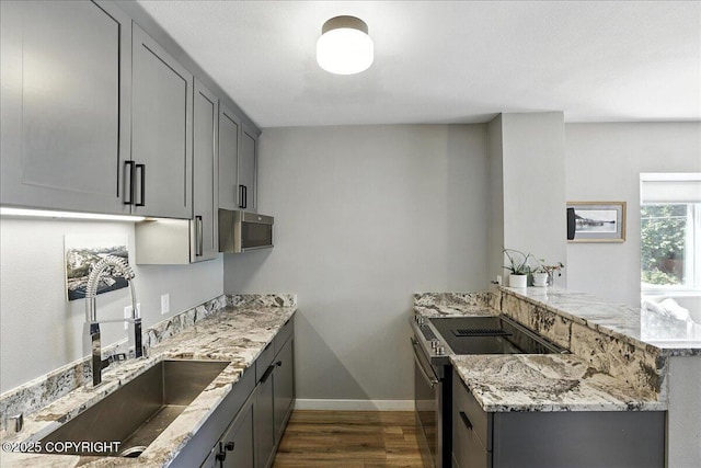3601 Oregon Dr # 1, Anchorage, AK 99517 - kitchen with stainless steel appliances, a peninsula, dark wood-style flooring, and gray cabinetry