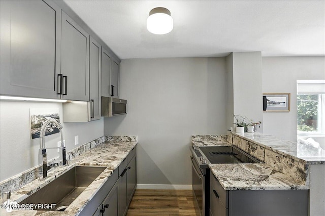 3601 Oregon Dr # 1, Anchorage, AK 99517 - kitchen with appliances with stainless steel finishes, a peninsula, dark wood finished floors, and gray cabinets