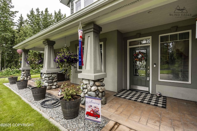 17237 E Smith Rd, Palmer, AK 99645 - doorway to property featuring covered porch and stucco siding