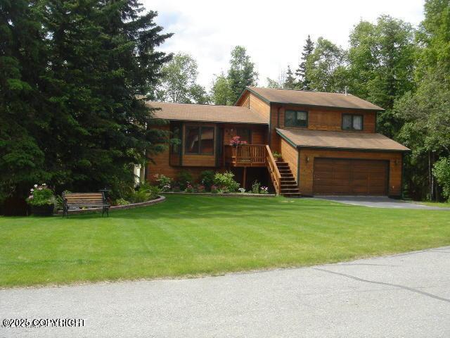 9636 Nulato Cir, Eagle River, AK 99577 - split level home featuring an attached garage, stairway, a front lawn, and driveway