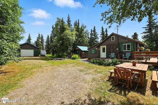 57541 Clam Diggers Ave, Clam Gulch, AK 99568 - view of green lawn with a wooden deck, a garage, and an outbuilding