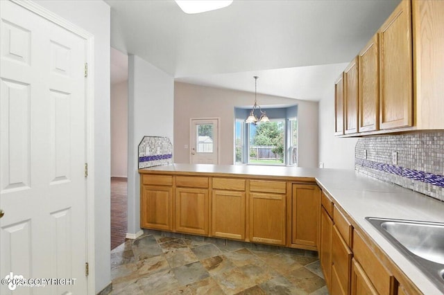 7851 Alpine View Cir, Anchorage, AK 99507 - kitchen featuring light stone finish flooring, decorative backsplash, light countertops, pendant lighting, and brown cabinets