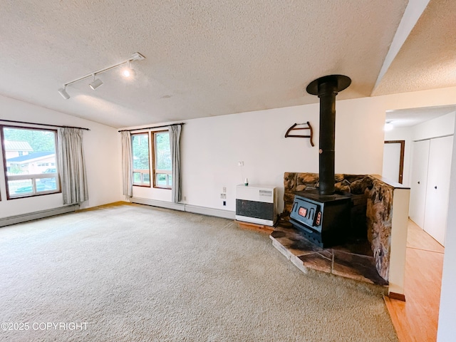 505 Unimak St, Petersburg, AK 99833 - unfurnished living room with lofted ceiling, a baseboard radiator, a textured ceiling, a wood stove, and track lighting
