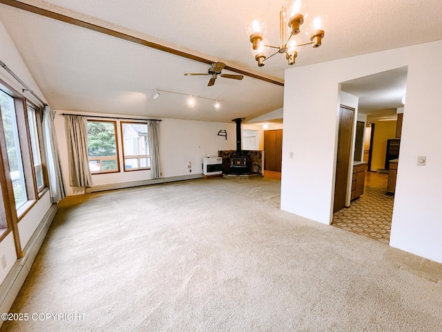 505 Unimak St, Petersburg, AK 99833 - unfurnished living room featuring a baseboard heating unit, a wood stove, light colored carpet, ceiling fan, and vaulted ceiling
