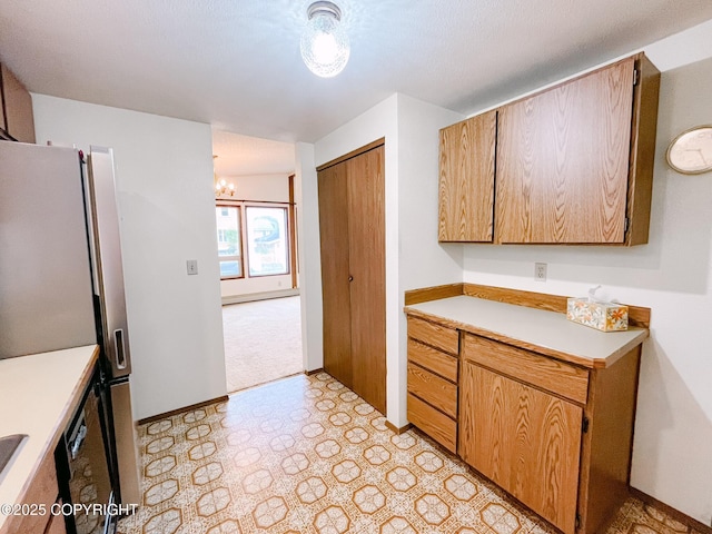 505 Unimak St, Petersburg, AK 99833 - kitchen with light floors, light countertops, freestanding refrigerator, and a chandelier