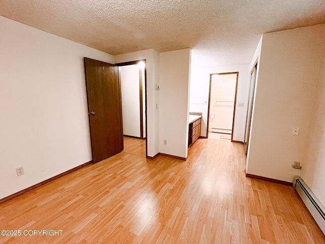 505 Unimak St, Petersburg, AK 99833 - empty room with a baseboard radiator, light wood-style floors, and a textured ceiling