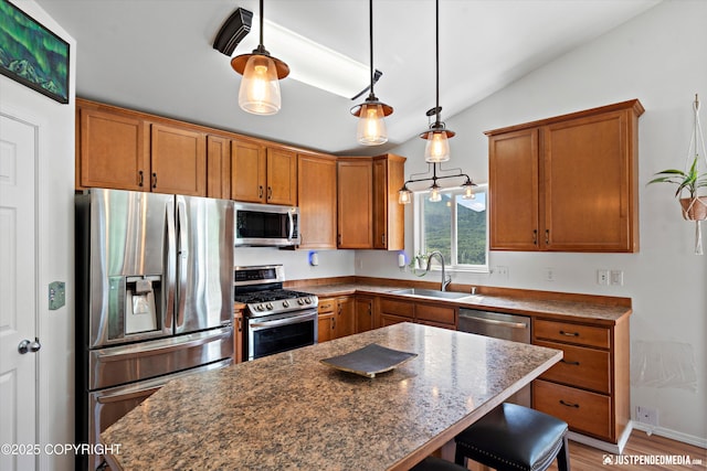 9166 Eagle River Ln, Eagle River, AK 99577 - kitchen featuring stainless steel appliances, lofted ceiling, brown cabinetry, a kitchen breakfast bar, and a kitchen island