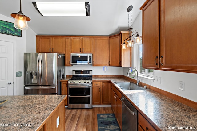 9166 Eagle River Ln, Eagle River, AK 99577 - kitchen featuring appliances with stainless steel finishes, brown cabinets, light wood-style flooring, and decorative light fixtures