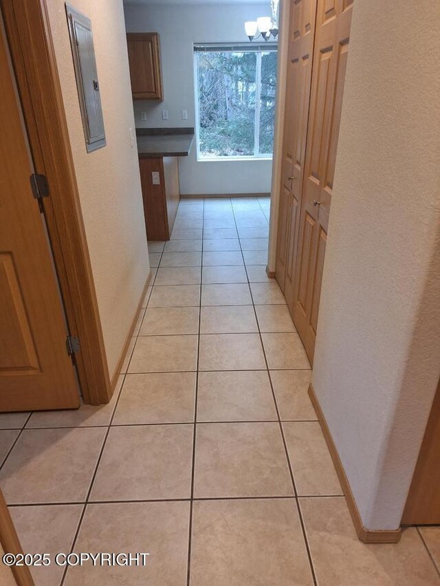 408 Eadies Way, Kenai, AK 99611 - hallway featuring electric panel, light tile patterned flooring, and a chandelier