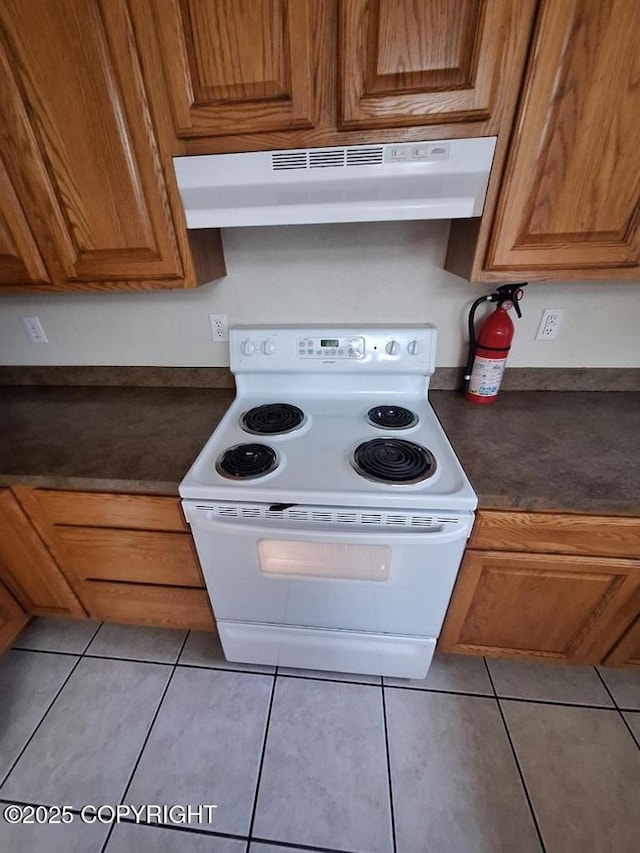 408 Eadies Way, Kenai, AK 99611 - kitchen featuring white electric stove, under cabinet range hood, dark countertops, and light tile patterned flooring