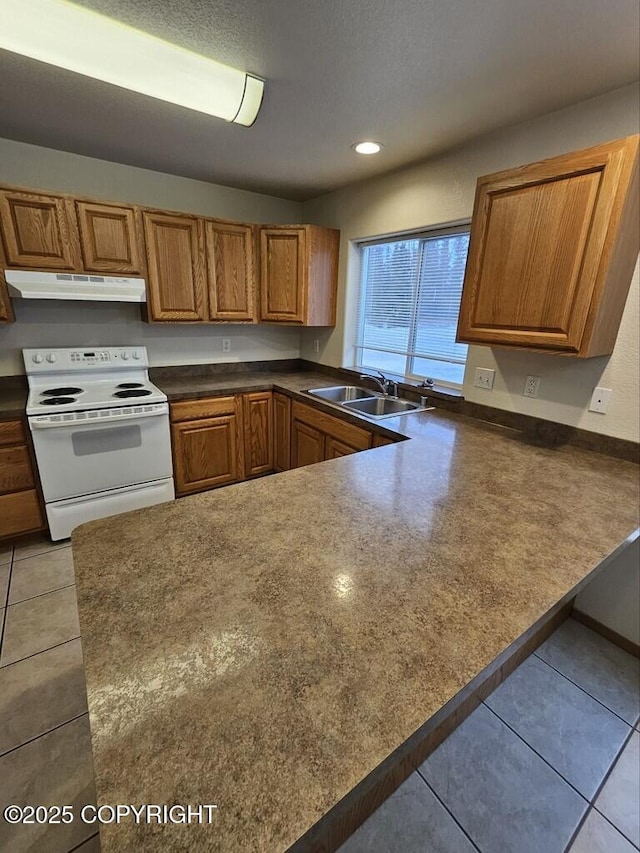 408 Eadies Way, Kenai, AK 99611 - kitchen with white electric stove, under cabinet range hood, a peninsula, light tile patterned floors, and brown cabinets