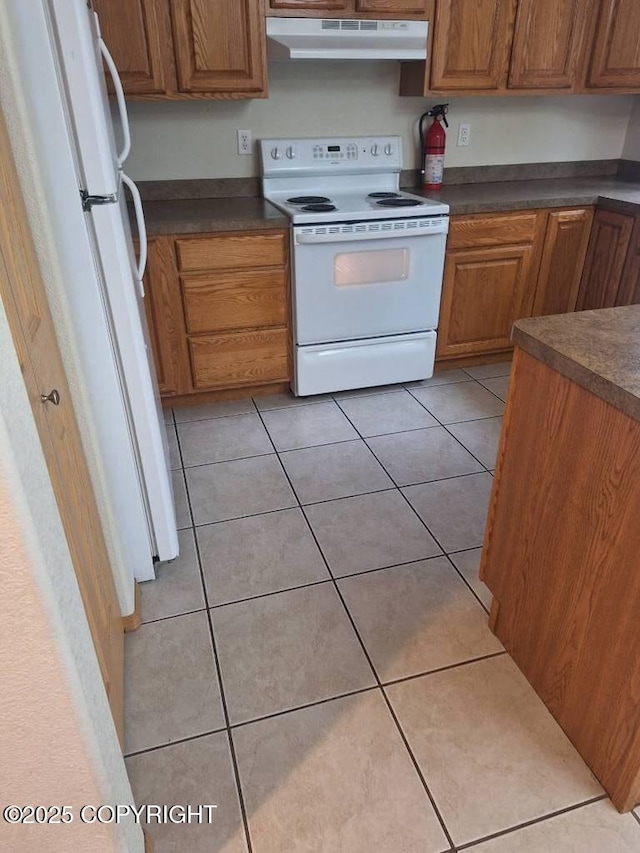 408 Eadies Way, Kenai, AK 99611 - kitchen with white appliances, under cabinet range hood, dark countertops, and light tile patterned flooring