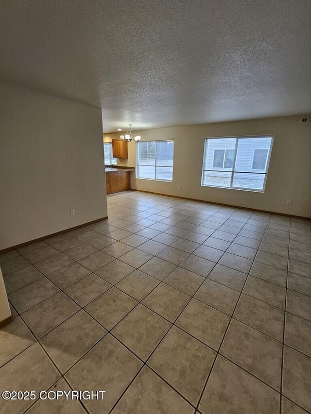 408 Eadies Way, Kenai, AK 99611 - unfurnished living room with a chandelier, a textured ceiling, and light tile patterned floors