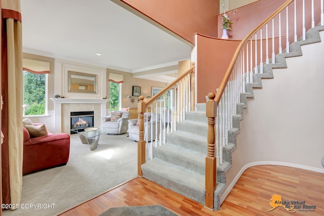 3931 Moonstar Cir, Anchorage, AK 99516 - staircase with wood finished floors, a fireplace, and crown molding
