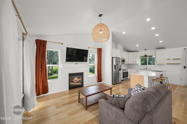 1460 E Esty Dr, Palmer, AK 99645 - living area featuring a glass covered fireplace, light wood-style floors, recessed lighting, and high vaulted ceiling