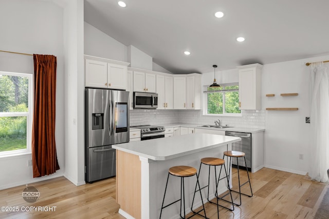 1460 E Esty Dr, Palmer, AK 99645 - kitchen with stainless steel appliances, white cabinets, backsplash, a breakfast bar, and a kitchen island