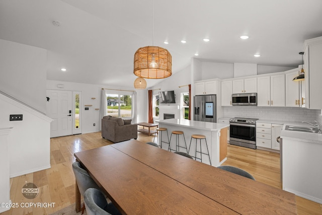 1460 E Esty Dr, Palmer, AK 99645 - dining room with light wood-style floors, vaulted ceiling, recessed lighting, and a fireplace